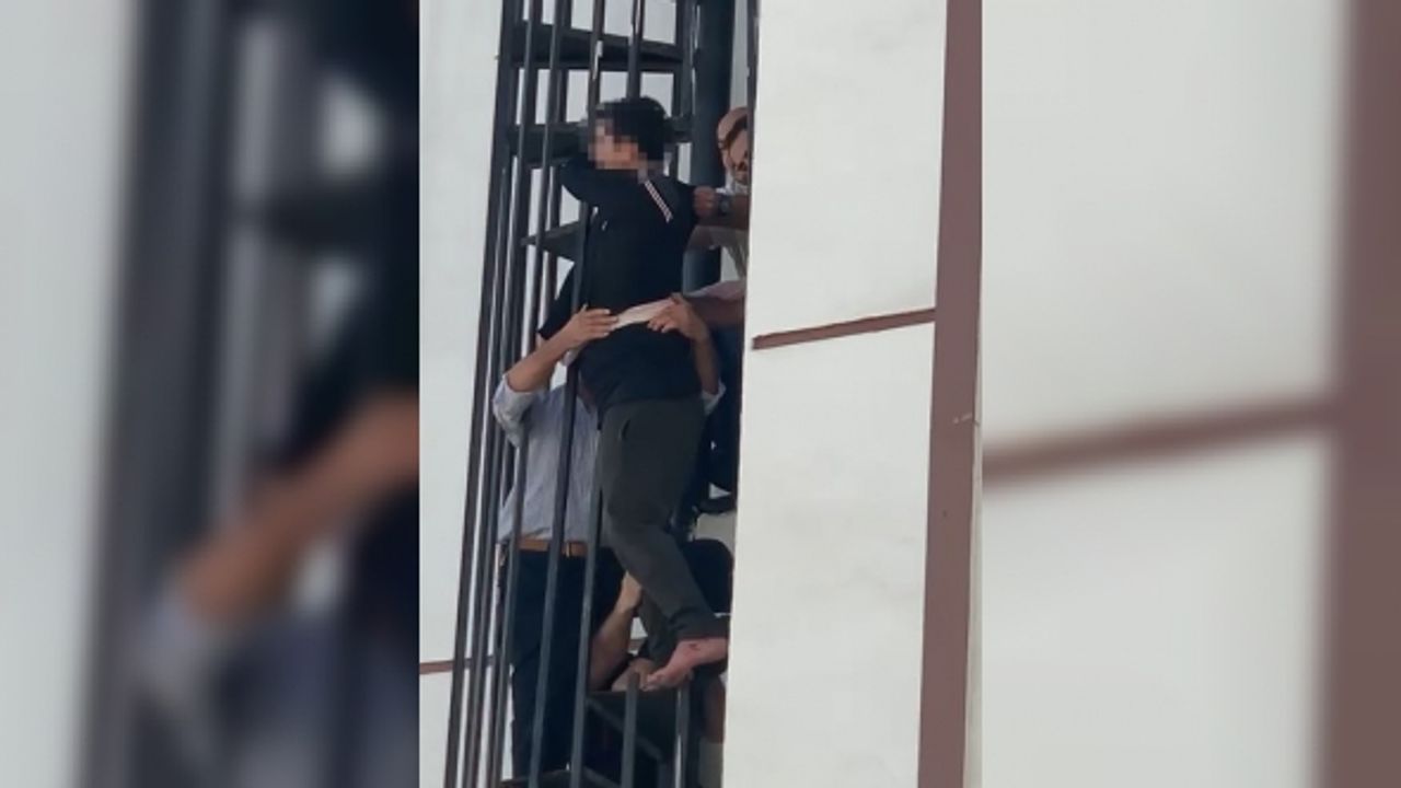 Yangın merdivenine sıkışan adam düşmemesi için çarşafla demire bağlandı