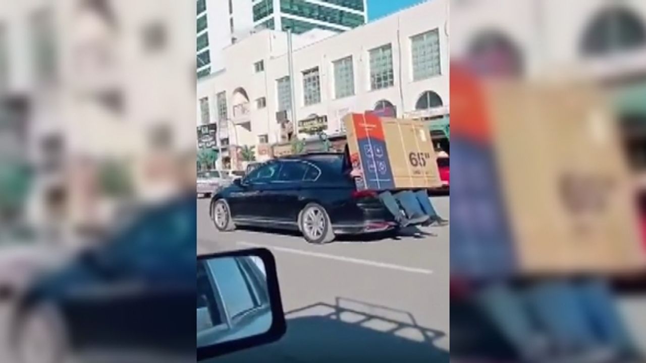 Lüks otomobilin bagajına oturan kişiler 65 inç ekran televizyonu böyle taşıdı