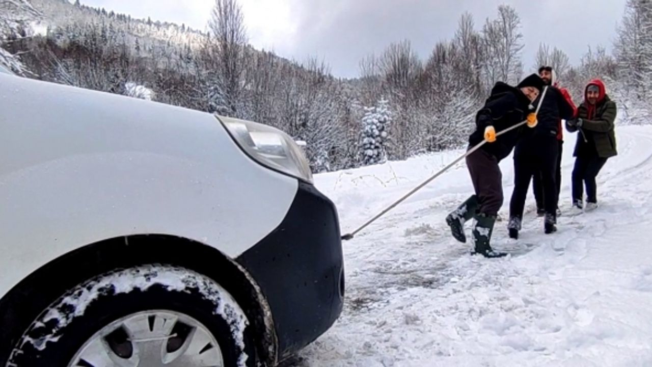 Aracı kurtarmak için her yolu deneyen köylülerin yardımına karla mücadele ekipleri yetişti