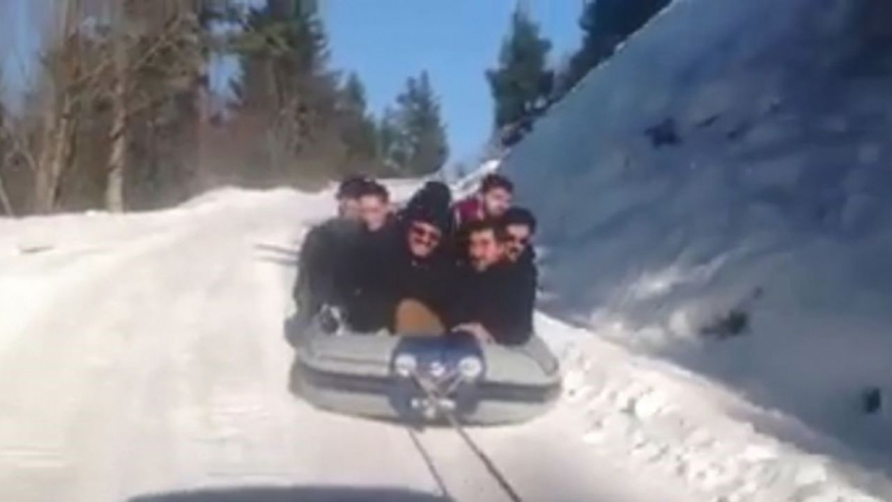 Araçlarına bağladıkları rafting botuyla kar üstünde kayarak çocuklar gibi eğlendiler