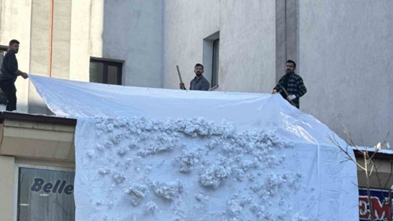 Vatandaşlar çatıdaki kar kütlelerini brandayla indirdi