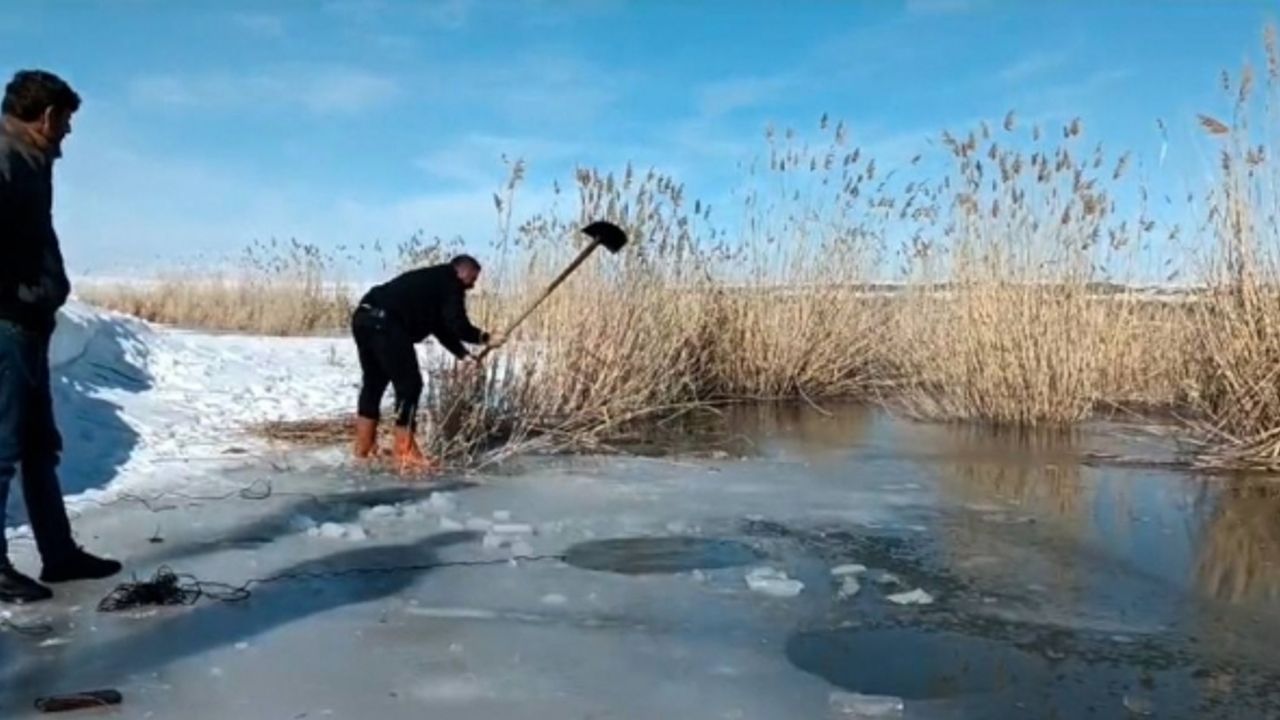 Yüzeyi donmuş nehirde buzu kırıp balık avlıyorlar